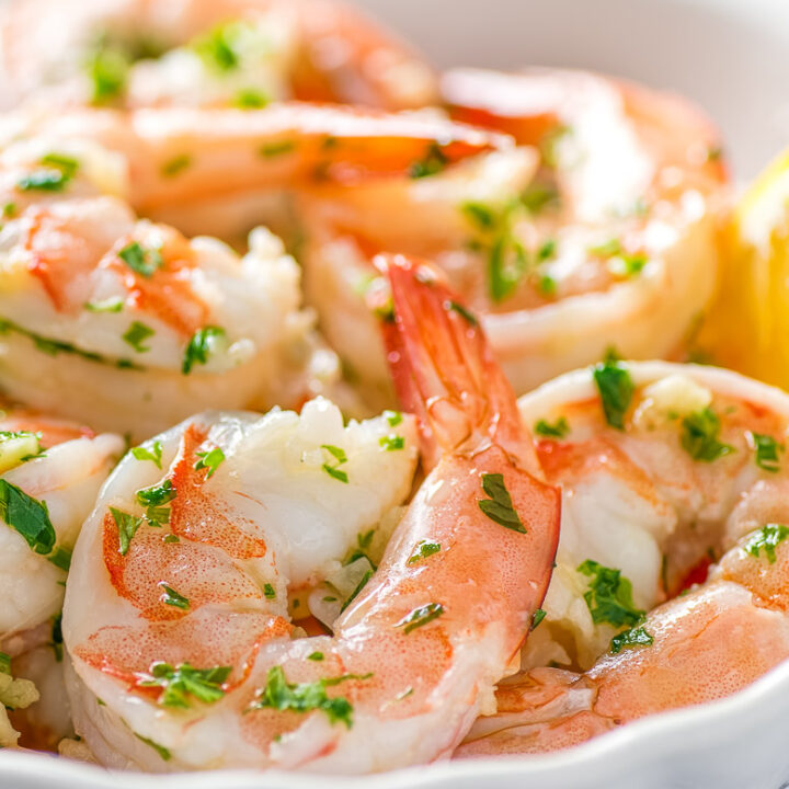 instant pot shrimp scampi in a white bowl with a lemon wedge